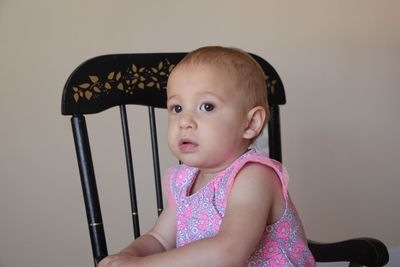 Portrait of cute girl sitting on chair