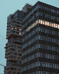 Low angle view of old modern buildings against clear sky