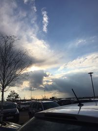 Cars on road against sky during sunset