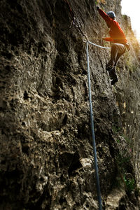 Low angle view of a man rock climbing