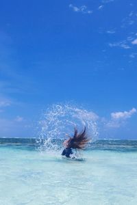 Woman tossing hair in sea