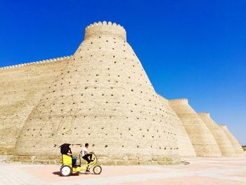 Men riding motorcycle against sky