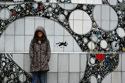 Woman standing against graffiti wall