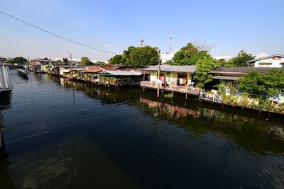 Scenic view of river by building against sky