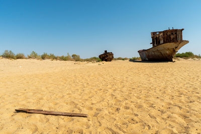 Old ruins on beach against clear blue sky