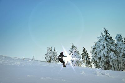Full length of man paragliding against clear sky during winter