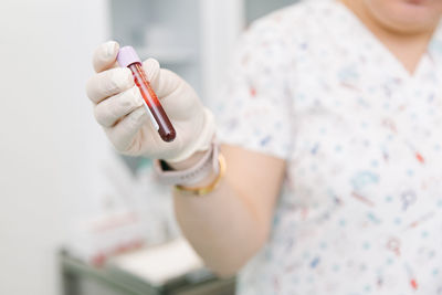 Midsection of woman holding blood sample