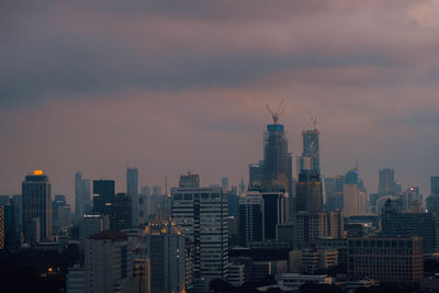 Modern buildings in city against sky at sunset