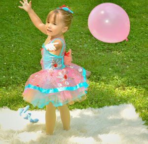 Little girl playing with balloon at park