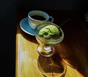 High angle view of green tea in ice cream glass on table