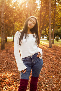 Portrait of beautiful young woman standing at park during autumn