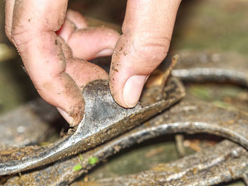 Fingers touch old brushed orthopedic horseshoes. removed used steel horse hoof cover.