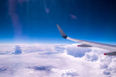 Airplane flying over cloudscape against sky