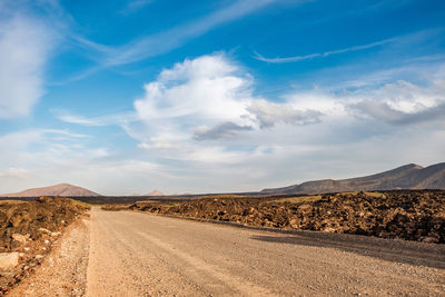 Road amidst desert against sky