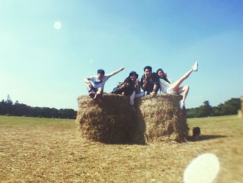 People on grassy field against sky