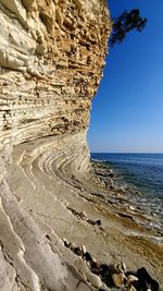 Rock formation on beach against clear sky