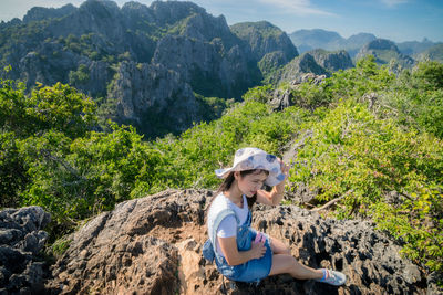 Woman on rock against mountains