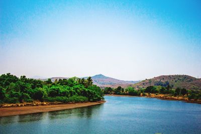 Scenic view of lake against clear blue sky