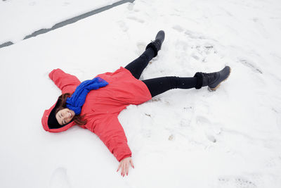 High angle view of woman making snow angel on land