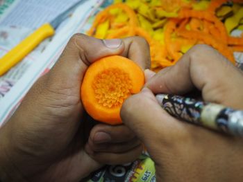 High angle view of person hand holding orange