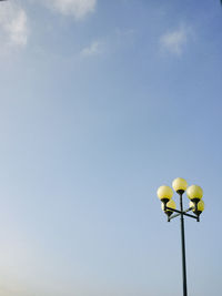 Low angle view of street light against blue sky