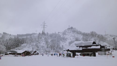 People on snow covered mountain against sky