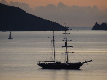 Boat sailing in sea against sky during sunset