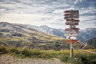 Information sign on field by mountains against sky