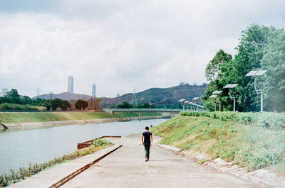 Rear view of woman walking on road