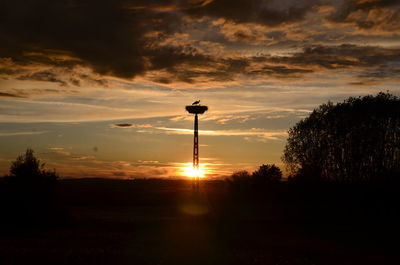 Silhouette street light against sky at sunset