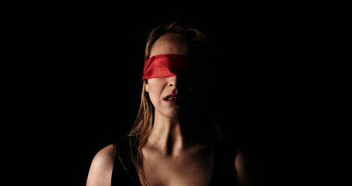 Portrait of woman against black background