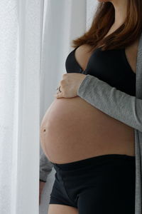 Midsection of woman standing against wall