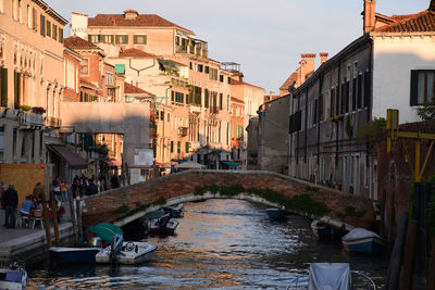 Canal amidst buildings in city against sky