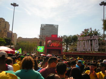 People on street in city against sky