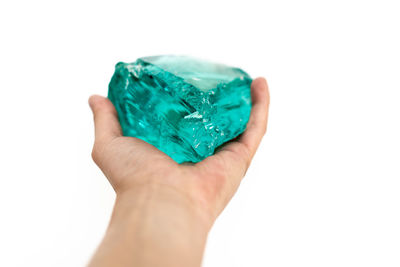 Close-up of hand holding blue over white background