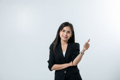 Portrait of a smiling young woman against white background