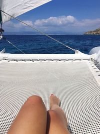 Low section of woman on sea against sky