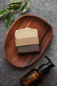 Handmade natural soap bar, massage oil and green leaf on a concrete background