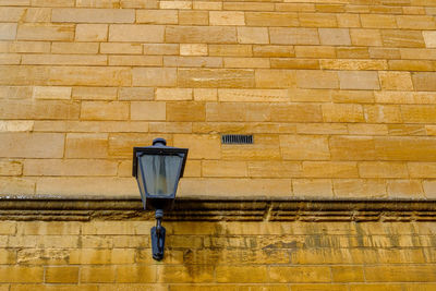 Close-up of security camera on brick wall