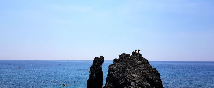 Rock formation in sea against sky