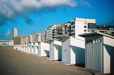 View of beach cabins against blue sky. 