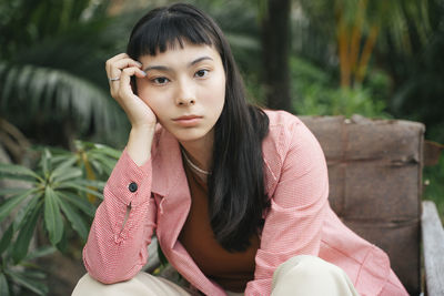 Portrait of young woman sitting on bench