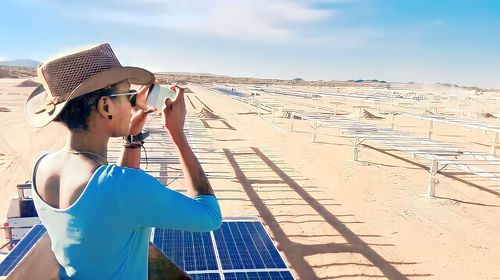 Photovoltaic/ solar farm. rear view of woman standing on street. solar panels 