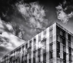 Low angle view of office building against cloudy sky