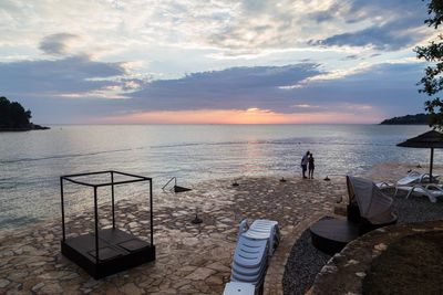 Couple on shore during sunset