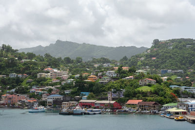 Scenic view of townscape by mountains against sky