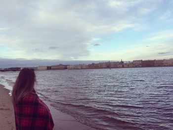 Rear view of woman on river against sky