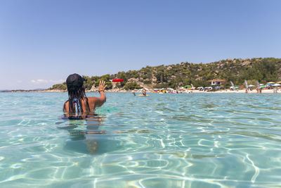 Happy young couple playing with a plastic disc in the sea. travel, vacation and fun