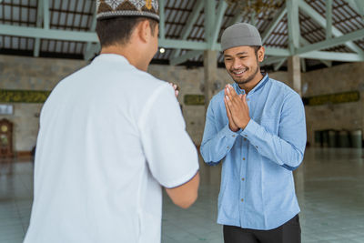 Smiling men greeting at mosque