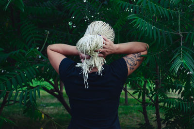 Rear view of woman standing against plants